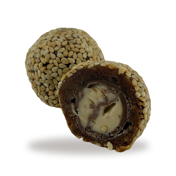 A Date Tahini Sesame cut open, showing the milk chocolate shell and tahini center inside