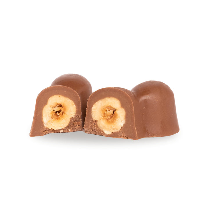 A milk chocolate Three Hazelnut broken open, showing the whole hazelnuts inside