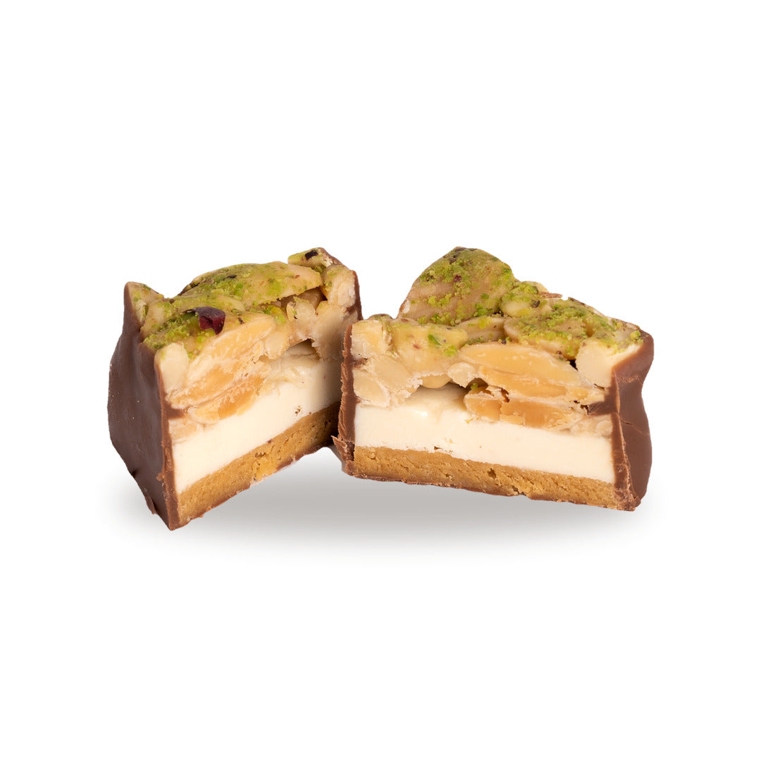 A dark chocolate Madlouka broken open, showing the cashew inside