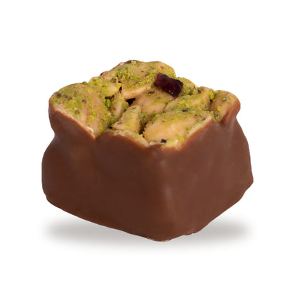 A whole Madlouka — a dark chocolate square with cashew