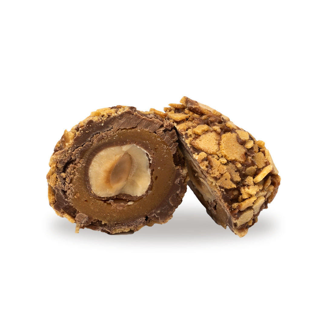 A milk chocolate Hazelnut Caramel Feuilletine broken open, showing the filling inside