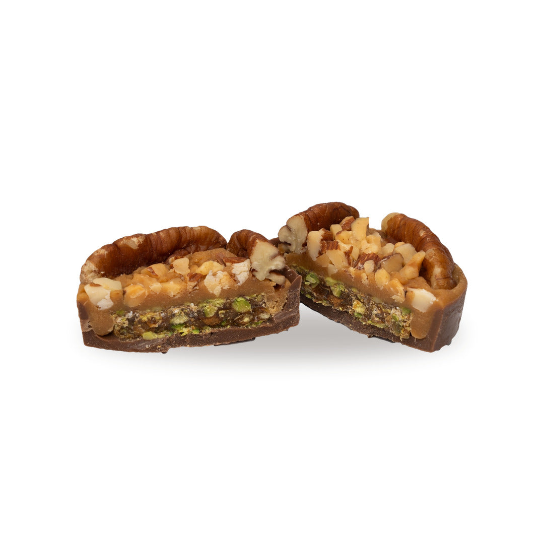 A milk chocolate Caramel Pecan Croquant broken open, showing the almond inside