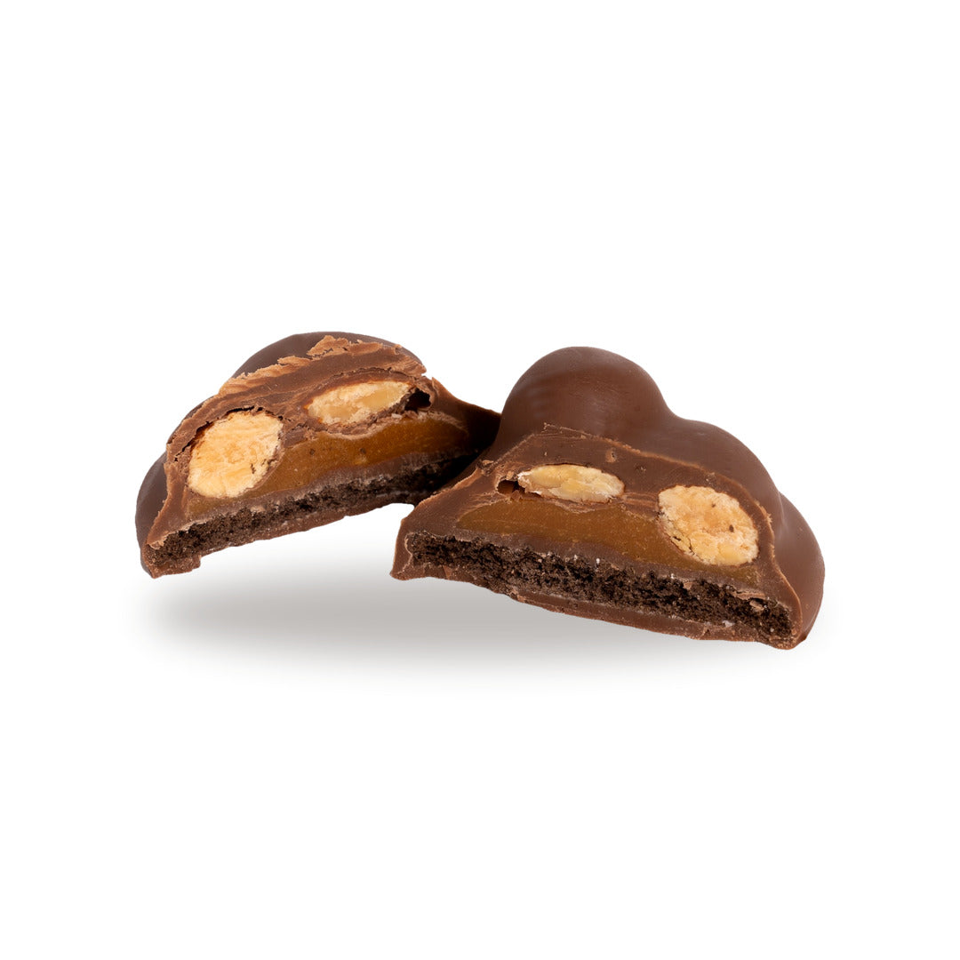A chocolate Cocoa Cookie Caramel broken open, showing the hazelnut inside