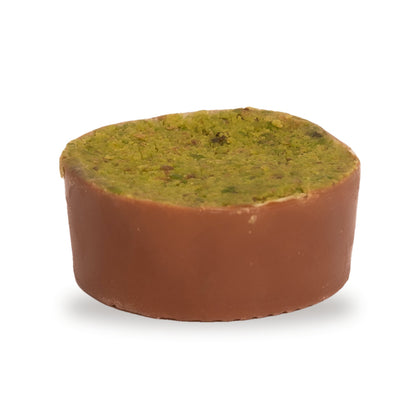 A whole Bouza Ashta — a round chocolate topped with pistachio green