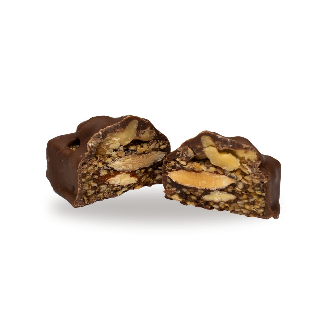 A milk chocolate Fig Sesame Walnut broken open, showing the filling inside