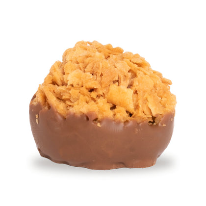 A whole Pistachio Crêpe Crunch — a milk chocolate round