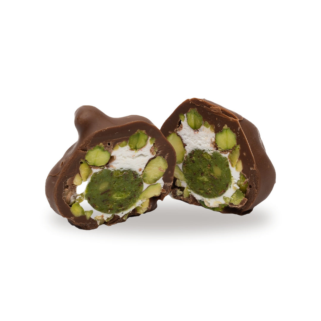 A milk chocolate Pistachio Fondant broken open, showing the filling inside