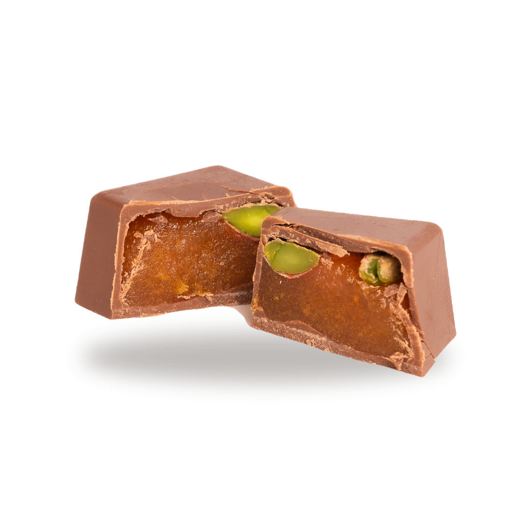 A milk chocolate Apricot Pistachio broken open, showing the filling inside