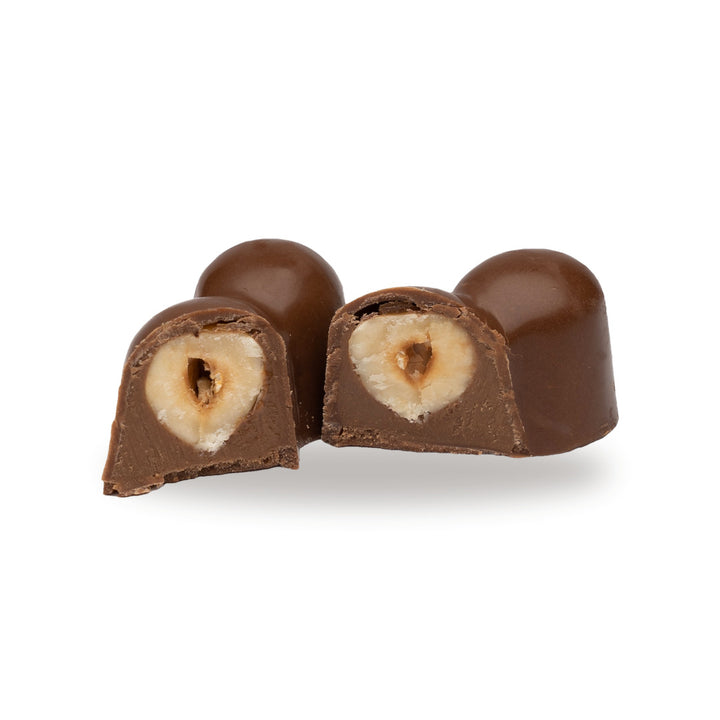 A dark chocolate Three Hazelnut broken open, showing the filling inside
