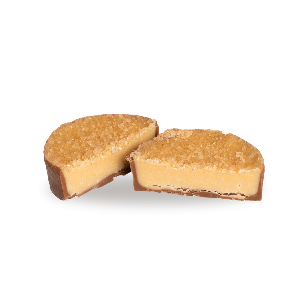 A Crème Brûlée broken open, showing the pale vanilla custard filling inside