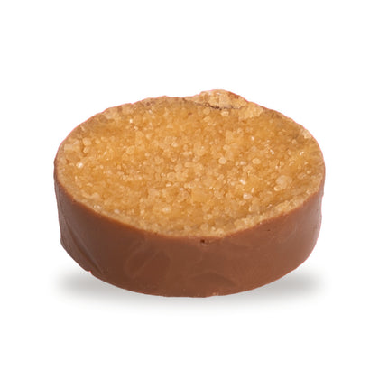 A whole Crème Brûlée — a round milk chocolate with a textured golden top