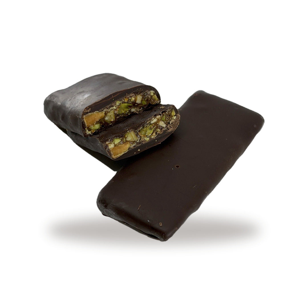 A Pistachio Croquant (Dark) cut open, showing the pistachio croquant inside the dark chocolate