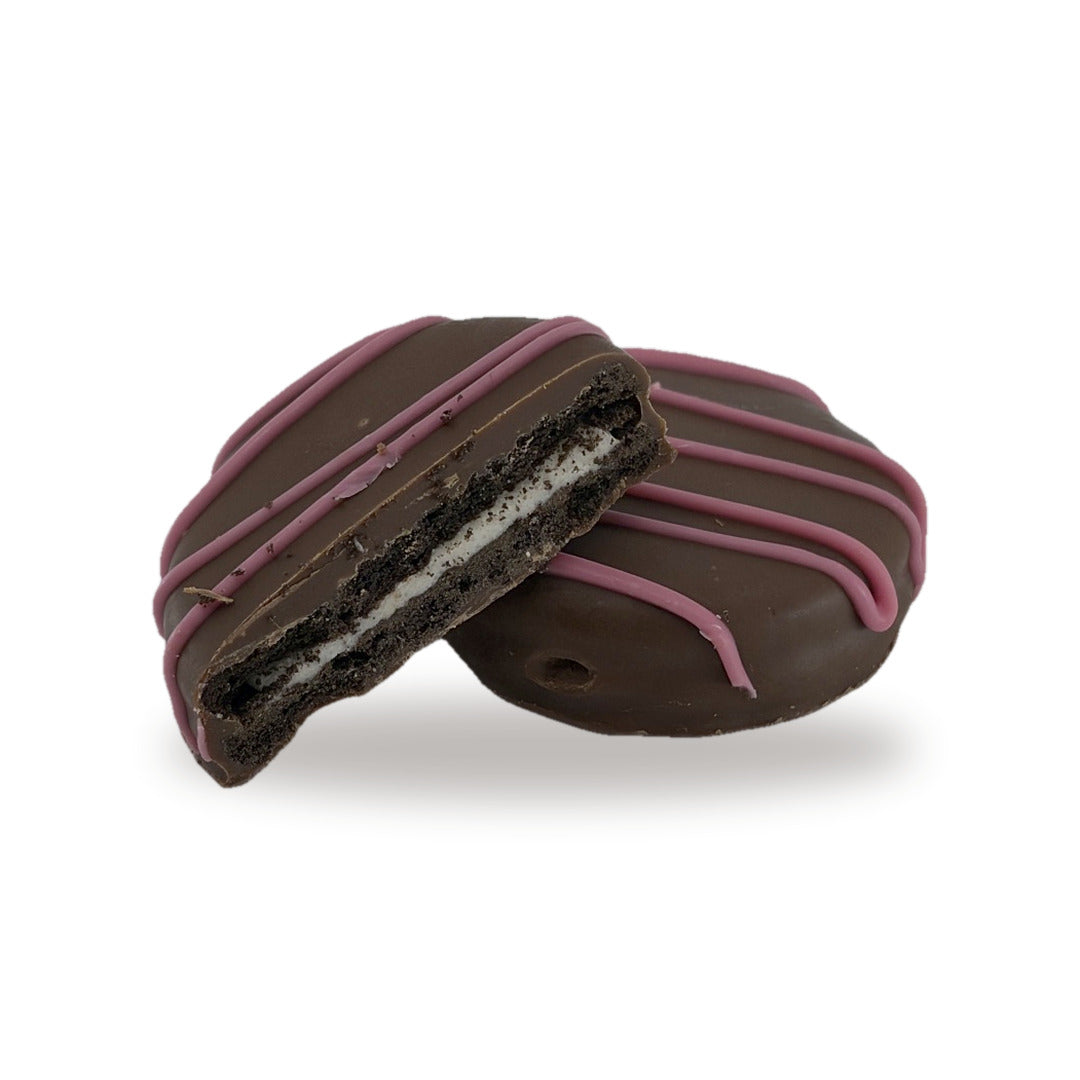 A Cocoa Cookie Pink cut open, showing the cocoa cookie and cream filling inside the milk chocolate shell