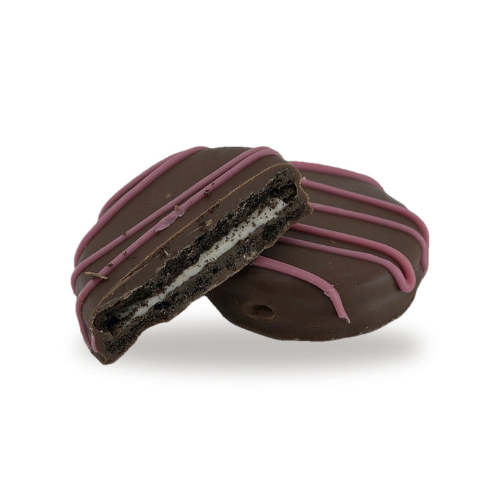 A Cocoa Cookie Pink cut open, showing the cocoa cookie and cream filling inside the milk chocolate shell