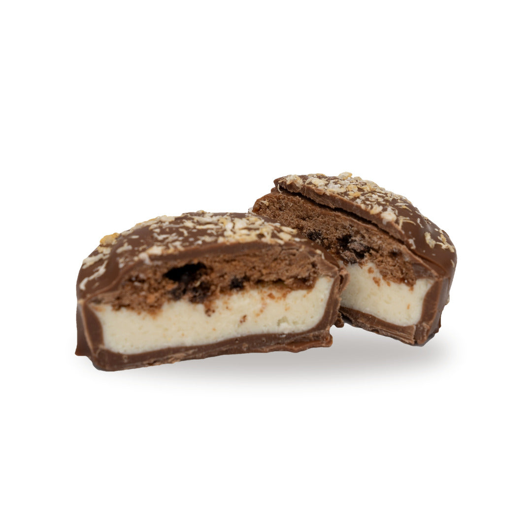 A milk chocolate Double Coconut Cookie broken open, showing the filling inside