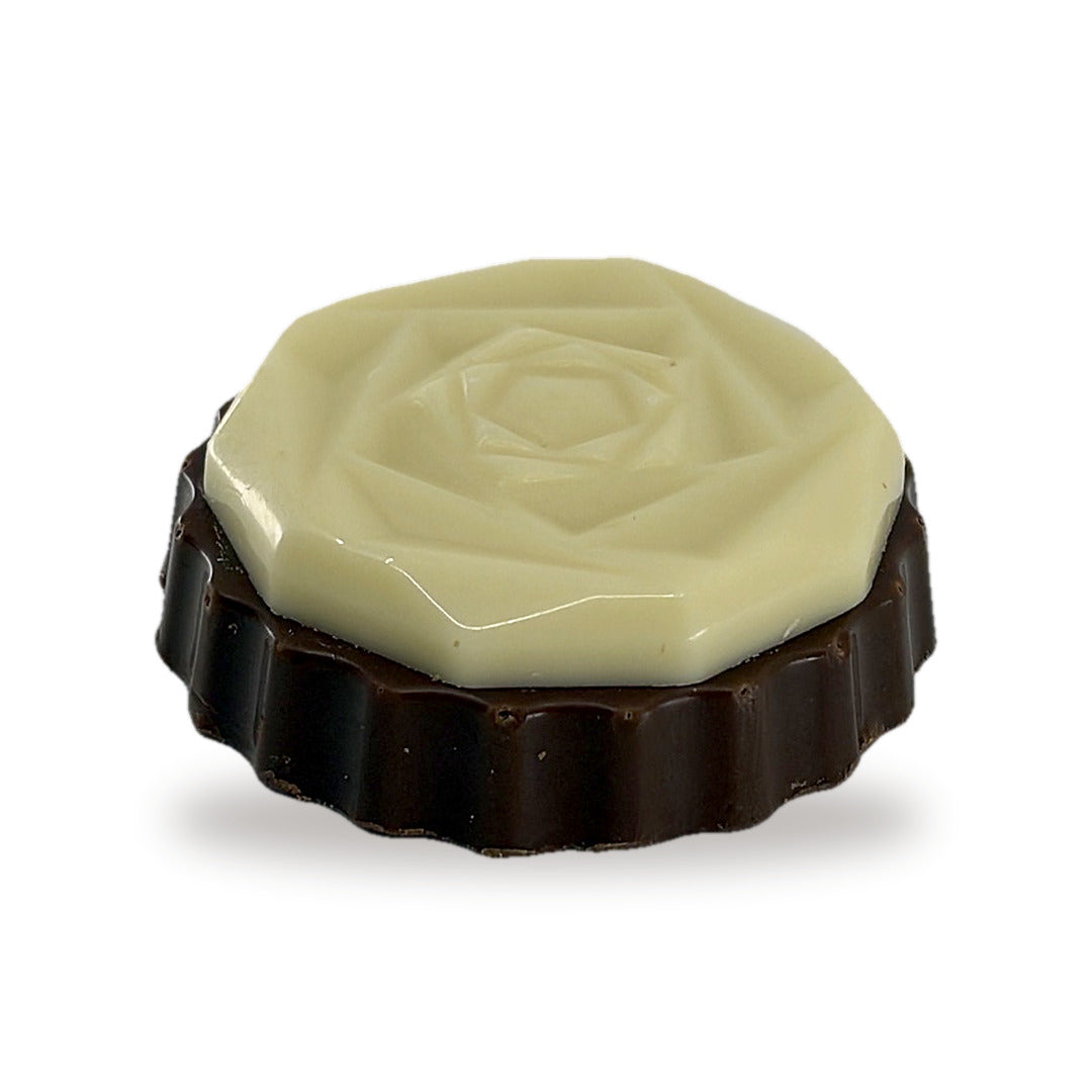 A whole Flower White Praline — a fluted milk chocolate round topped with a white chocolate flower