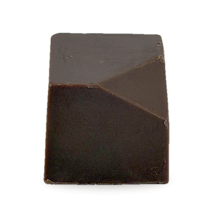A whole Baklava Caramel — a milk chocolate cube with a faceted top