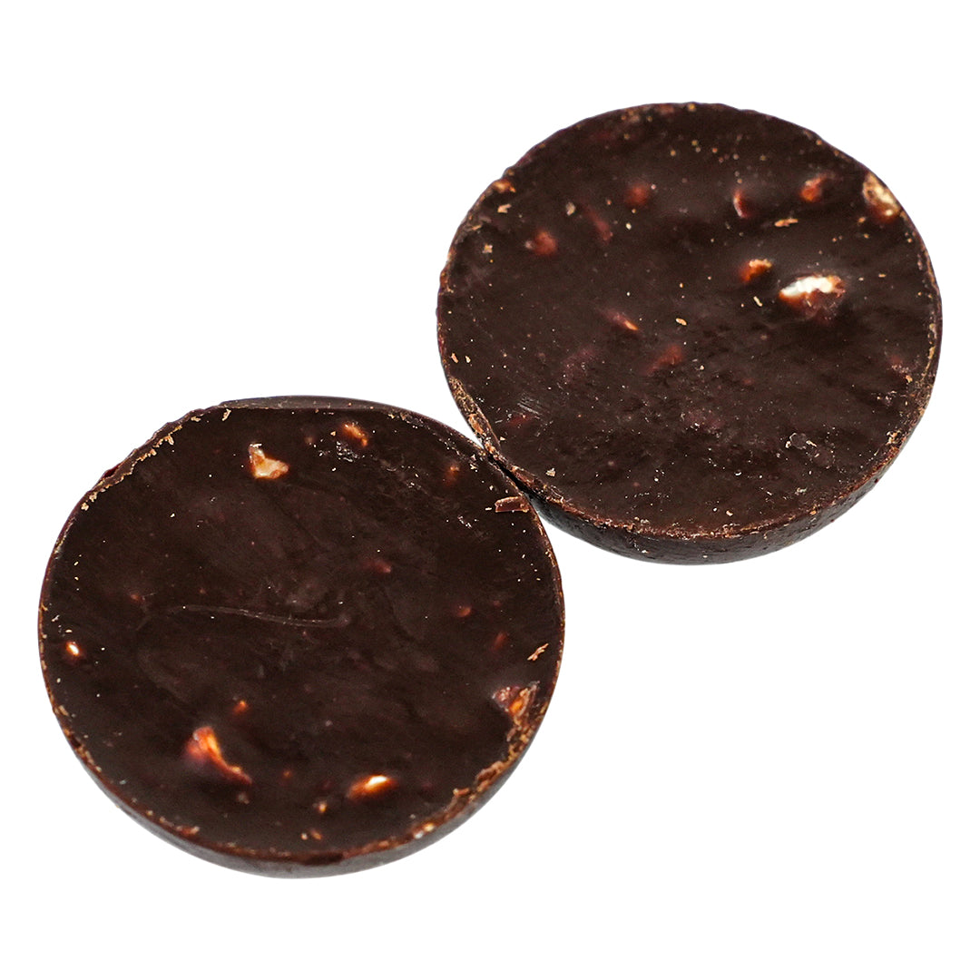 Dark chocolate ball cut open showing nut pieces inside.